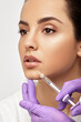 © Peakstock - Sensual female lips, procedure lip augmentation. Syringe near woman's mouth, injections for increase lips shape, high quality