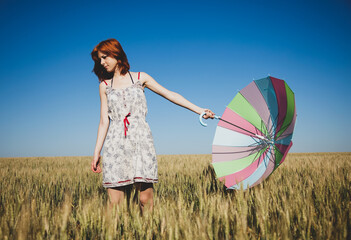 Wall Mural - Girl with umbrella at field