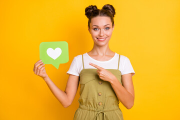 Wall Mural - Portrait of attractive trendy cheerful girl demonstrating paper card heart like web chat isolated over bright yellow color background
