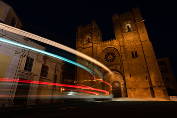 Lisbon city at night. Old town with traffic lights and famous Santa Maria cathedral at night.