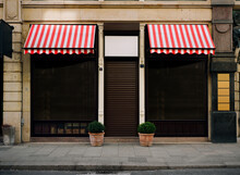 Photo Of Closed And Locked Clothier Or Dress Outfitter, Shop Front, Impact Of The Corona Virus Pandemic 2021 In Germany.