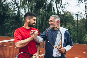 two men handshake on court after tennis game