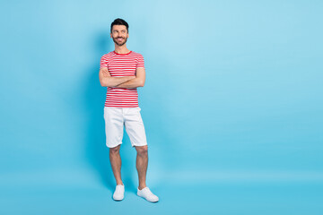 Poster - Full body photo of dreamy happy young man look empty space hold hands folded isolated on pastel blue color background