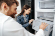 © fotofabrika - Young couple selecting new refrigerator in household appliance store