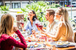 © Davide Angelini - Multiracial people drinking red wine at open bar restaurant - Group of friends laughing having fun dining together outdoor -  Bright filter
