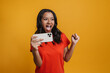 © Drobot Dean - Black excited woman making winner gesture while playing game on cellphone