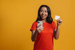 © Drobot Dean - Black young woman smiling while holding credit card and cellphone