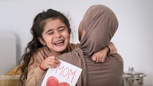 Muslim Daughter Hugging Mommy Holding Mother's Day Greeting Card Indoor