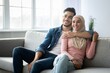 © Prostock-studio - Positive arab couple sitting on couch at home