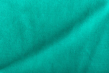 Green Fleece Background With Wave. Surface Of Fabric, Textile.