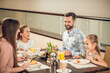 © zinkevych - Smiling family sitting at the table and looking happy