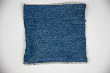 destroyed torn denim blue jeans frayed flap patch fabric frame on white background