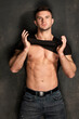 Sexy sport muscle strongface guy  in denim blue jeans and black t-shirt on black wall background