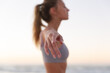 © Wavebreak Media - Caucasian woman performing stretching exercise while standing at the beach