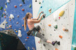 © Wavebreak Media - Caucasian woman climbing up a wall at indoor climbing gym