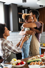 Wall Mural - happy family having fun together at home in the kitchen