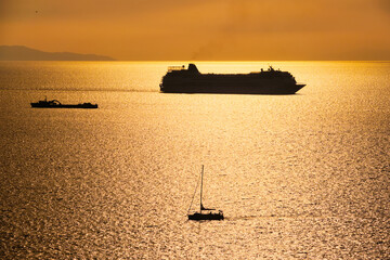 Cruise ship silhouette in Aegean sea on sunset