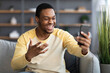 © Prostock-studio - Joyful black man having video conversation on phone, home interior