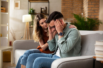 Wall Mural - Young man having a problem. Girlfriend comforting her sad boyfriend...