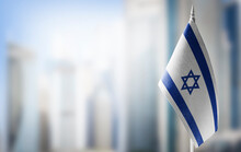 A Small Flag Of Israel On The Background Of A Blurred Background