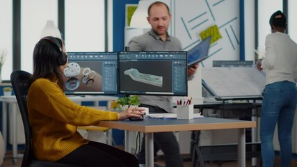 Professional workers using high-tech industrial program working on computer at mechanical piece design cad, sharing ideas about project using dual displays setup. Mnager analysing 3D gears shapes