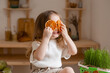 cute little girl eats natural pastille at home in a wooden kitchen. Food for children from natural products