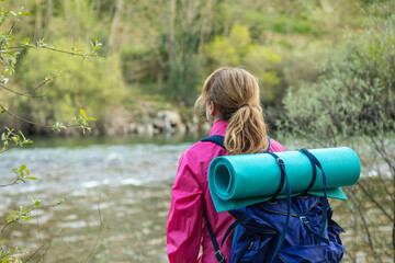 traveling woman with backpack practicing rural tourism