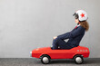 © Sunny studio - Successfull businesswoman driving toy car outdoor