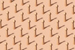 Creative pattern with equal wooden figures representing people on pastel orange background - concept of uniformity