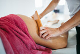 Fototapeta Sypialnia - Middle age woman at professional anti cellulite maderotherapy massage treatment. Close up shot.