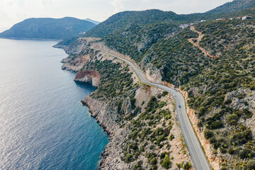 Wall Mural - Aerial view of curves coastline road alonge sea. Summer time road trip to sea by car on coast Highway