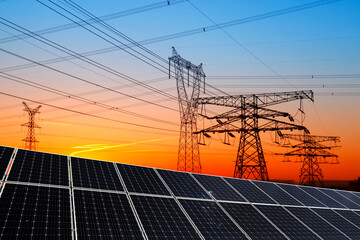 Solar panels and high voltage towers in the evening