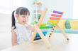 © gamelover - Pretty asian girl counting wood on abacus at home. Child education concept.