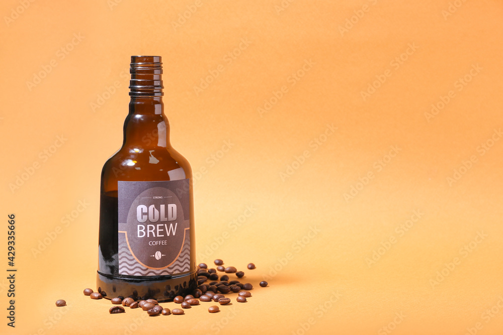 Bottle of cold brew and coffee beans on color background
