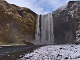 Fototapeta Łazienka - Beautiful front view of stunning waterfall Skógafoss (height 60m), a popular tourist destination on the south coast of Iceland near ring road, in winter season with snow and rugged rocks.
