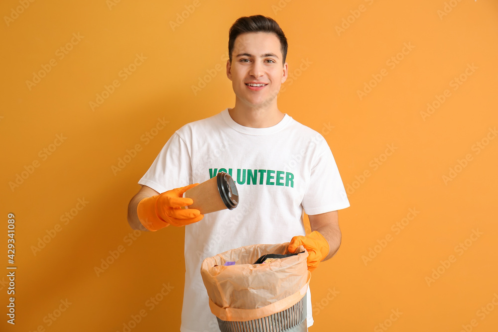 Volunteer with trash bin on color background