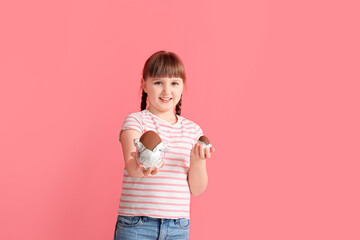 Poster - Cute little girl with chocolate Easter eggs on color background