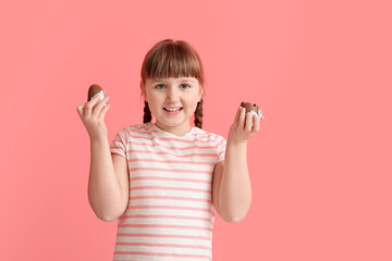 Poster - Cute little girl with chocolate Easter eggs on color background