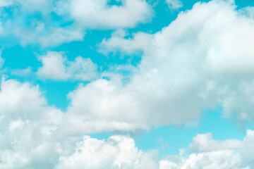 Teal blue sky with white clouds on a windy day