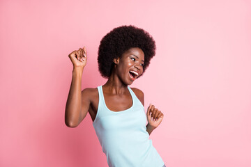 Sticker - Portrait of optimistic brunette curly lady dance look empty space wear blue top isolated on pastel pink color background