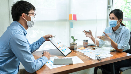 Wall Mural - Asian business man showing financial chart to colleagues and discussion about new project