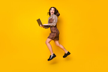 Canvas Print - Full size profile photo of optimistic brunette lady with laptop jump wear shirt dress sneakers isolated on vivid yellow background