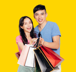 Wall Mural - Happy young couple holding the  shopping bags