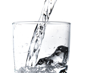 Glass of water being filled. Close up pouring clear water in transparent drinking glass over white background