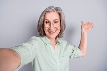 Sticker - Photo of happy cheerful funky funny mature woman show demonstrate taking selfie isolated on grey color background