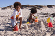 © Wavebreak Media - African american children having fun playing with sand at the beach