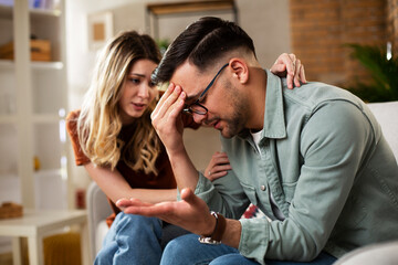 Wall Mural - Young man having a problem. Girlfriend comforting her sad boyfriend