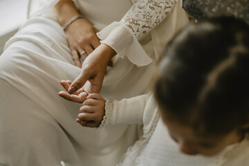 Canvas Print - Closeup shot of a young child holding her mother's hand