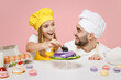 Teen girl dad father chef cook confectioner baker in yellow apron toque cap at table decorating pie with blackberry berry isolated on pink background Mousse cake food workshop master class process