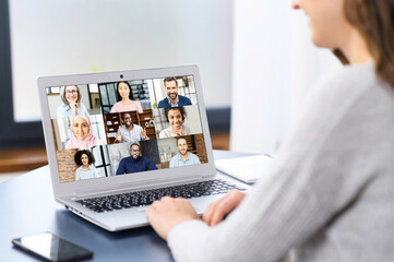 Webinars, online conference, video meeting. A young woman is using app on laptop for video connect with a many people at same time together at office. Distant work concept